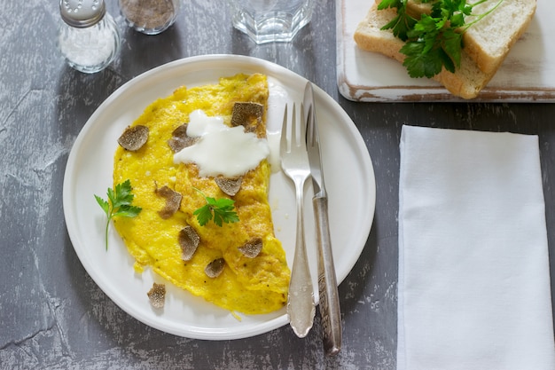 Omelet met truffel en peterselie, geserveerd met zure room