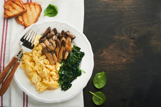 Omelet Spinach oyster mushroom and cheese omelet or frittata on dark old wooden background Breakfast idea Top view with copy space