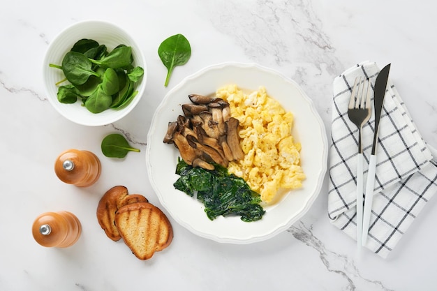 흰색 대리석 배경에 있는 오믈렛 시금치 굴 버섯과 치즈 오믈렛 또는 프리타타 아침 식사 아이디어 복사 공간이 있는 상위 뷰
