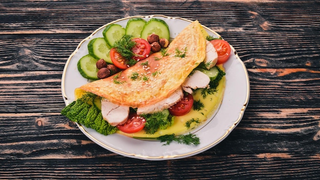 Omelet with chicken and fresh vegetables and nuts On a wooden background Top view Copy space