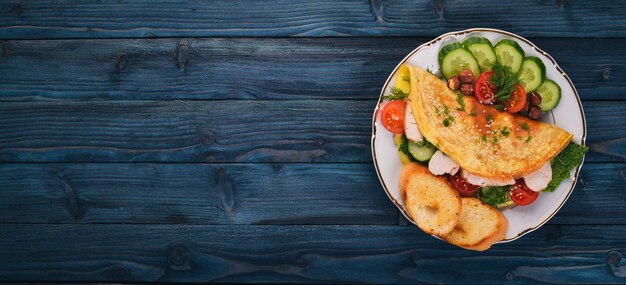 Omelet with chicken and fresh vegetables and nuts On a wooden background Top view Copy space