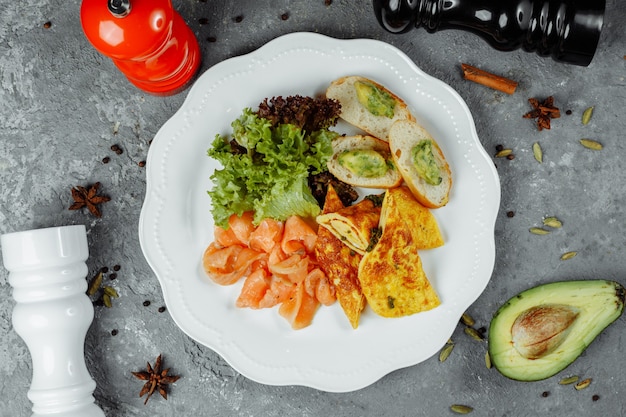 Omelet with red fish and vegetables, beautiful serving.