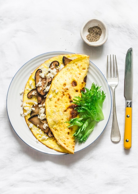 Omelet with shiitake and eringi mushrooms delicious healthy vegetarian brunch on a light background top view