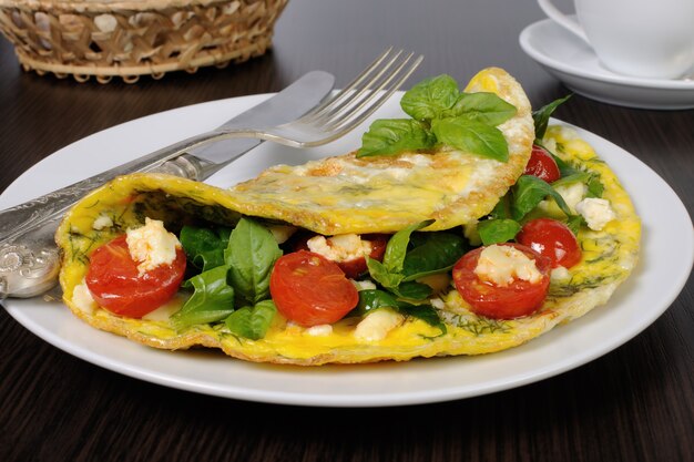 Foto frittata con spinaci, basilico, aneto, pomodorini e formaggio adyg