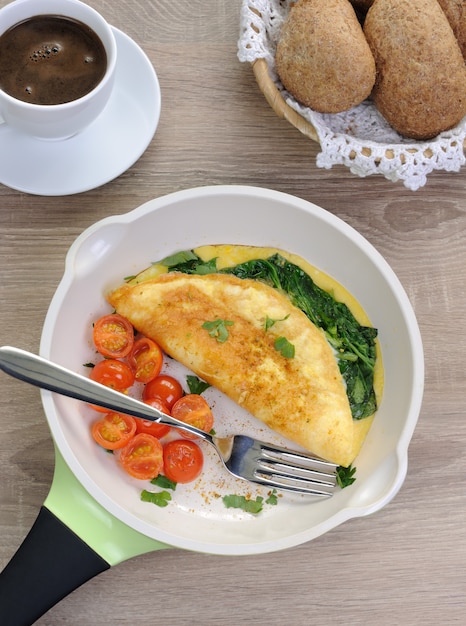 Frittata con spinaci, formaggio e pomodori arrostiti in padella