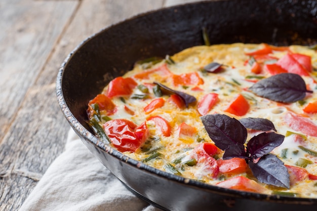 Omelet with vegetables in a pan close-up. 