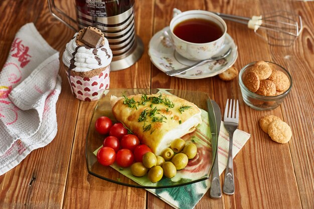 omelette, cake, biscuits, tomatoes, olives on the table