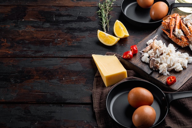 Photo omelette ingredients with pepper, crab meat, egg, cheese set, on dark wooden background , with copyspace  and space for text