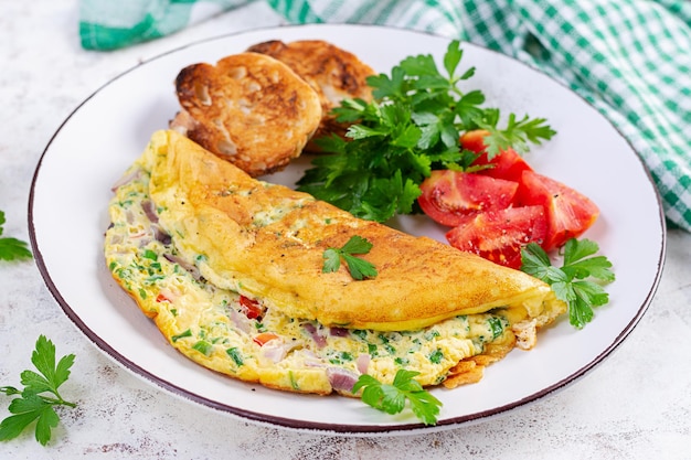 Omelette with tomatoes cheese and red onion on white plate Frittata italian omelet