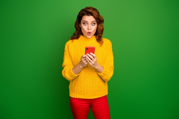 Ой, невероятно! женщина-пользователь социальных сетей astonoshed, использующая мобильный телефон, проверяет онлайн-новизну, впечатлена стильным свитером в стиле крика, изолированным над яркой блестящей цветной стеной