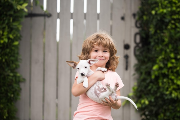 Omhelzen vrienden Kid jongen nam puppy uit opvang Geadopteerd dier Klein schattig huisdier vindt huis Puppy likt dankbaar het gezicht van een jongen Gelukkig kind met grappige emoties