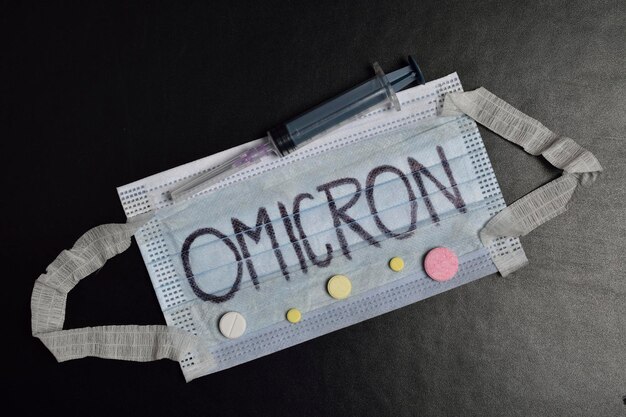 薬と注射器を備えたオミクロンコンセプトフェイスマスク