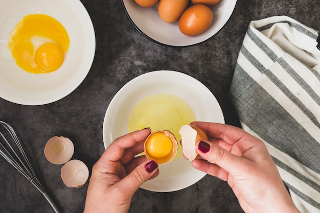 Omlette koken. De handen die van de vrouw omlette koken, een vers ei breken. Plat eten.