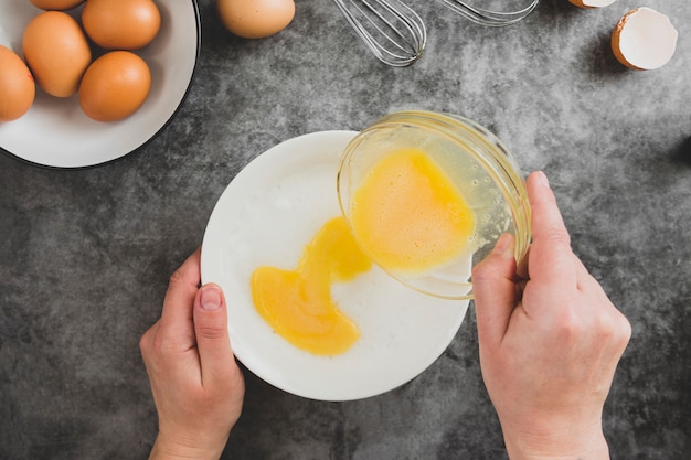 Omlette koken. De handen die van de vrouw omlette koken, een vers ei breken. Plat eten.