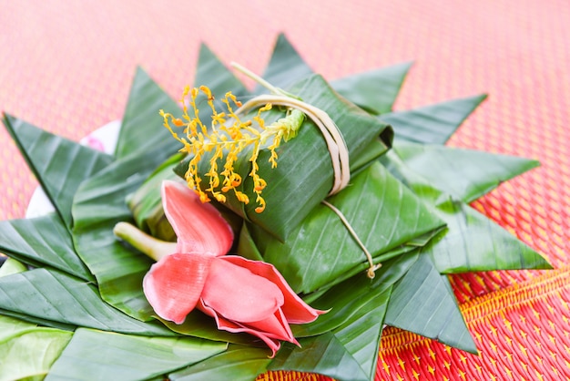 Omslag van het dessert de Thaise voedsel met banaanblad en bloemen