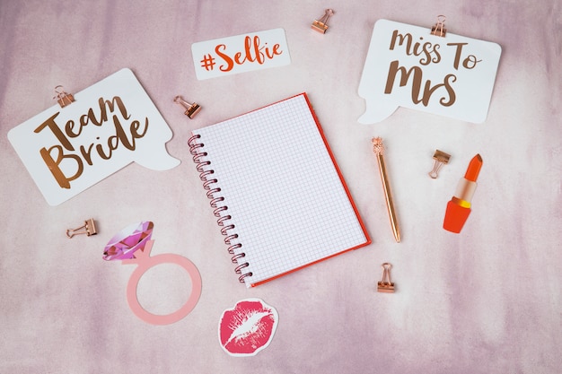 Фото На розовом фоне предметы для планирования девичника: наклейки, блокнот, ручка