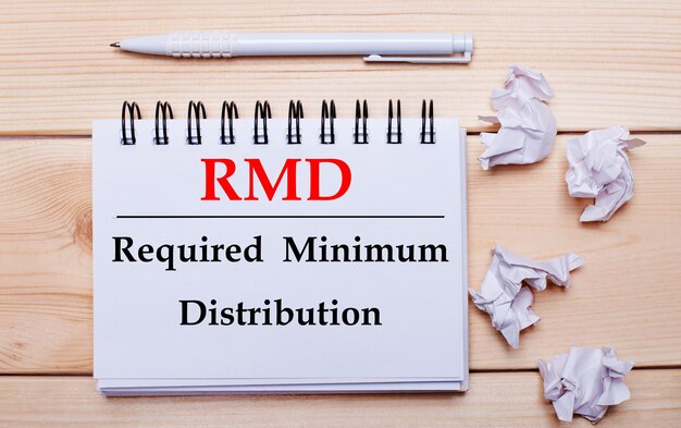 Фото На деревянном фоне белый блокнот с надписью rmd required minimum distribution