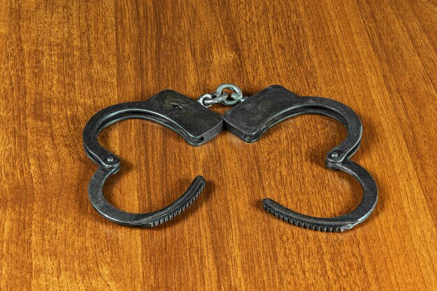Фото На деревянной поверхности металлические наручники