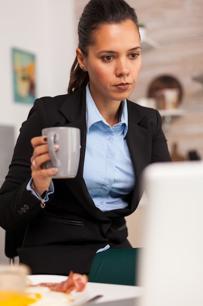 Onafhankelijke zakenvrouw zoekt op internet en geniet van de koffie