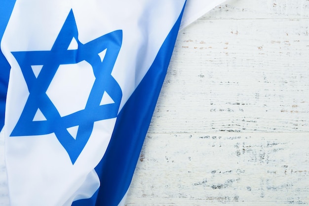 Onafhankelijkheidsdag van Israël Nationale Israëlische vlag met ster van David op witte houten achtergrond Close-up Nationale vlag met plaats voor tekst
