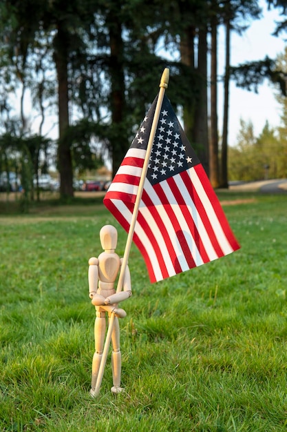 Onafhankelijkheidsdag VS. Veteranendag VS. Herdenkingsdagconcept. Houten paspop met Amerikaanse vlag