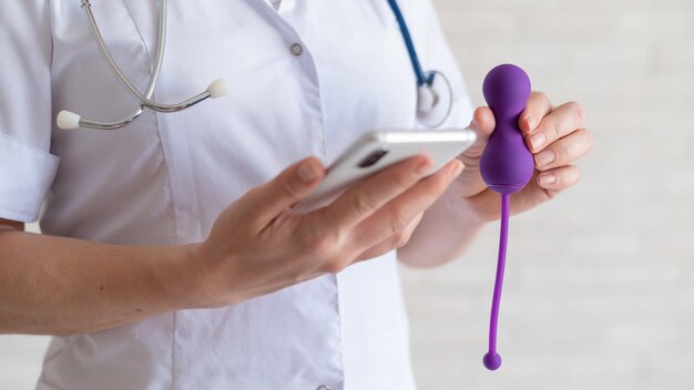 Onbekende gynaecoloog raadt een kegelsimulator aan om de gezondheid van vrouwen op peil te houden De dokter synchroniseert de vibrator met de smartphone Apparaat voor de bekkenbodemspieren