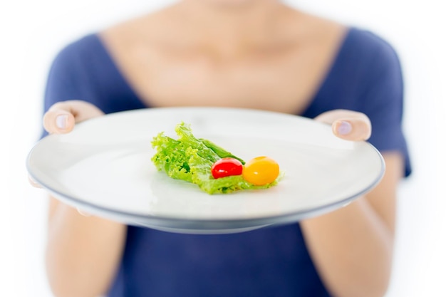 Onbekende vrouw die een kleine portie salade vasthoudt