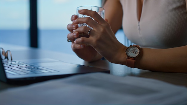 Onbekende zakenvrouw typen toetsenbord laptop close-up Handen houden whiskyglas