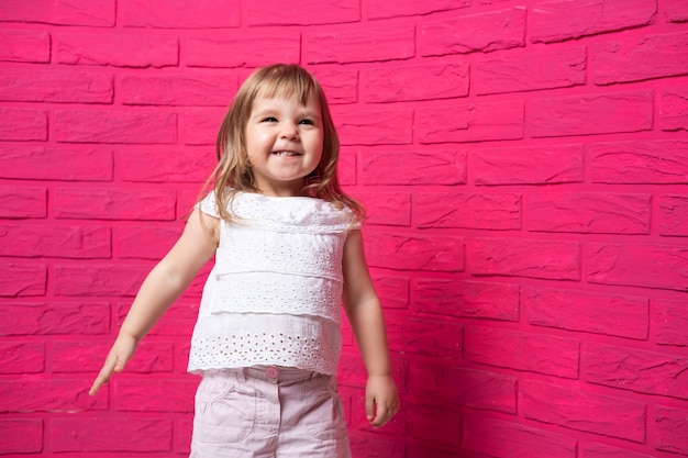 Onbezorgd vrolijk meisje dat hardop lacht giechelt op roze