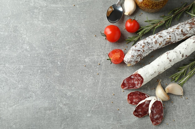 ÃÂ¡oncept of tasty food with salami sausage on gray textured background