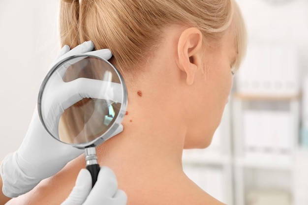 Oncologist examining female patient with magnifier in clinic Cancer awareness