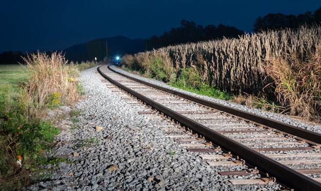 写真 夜の急な坂道を下る対向列車