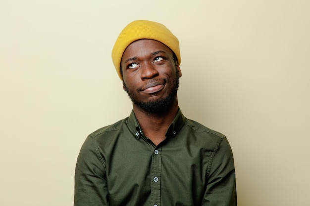 Onder de indruk van jonge afro-amerikaanse man in hoed met groen shirt geïsoleerd op een witte achtergrond