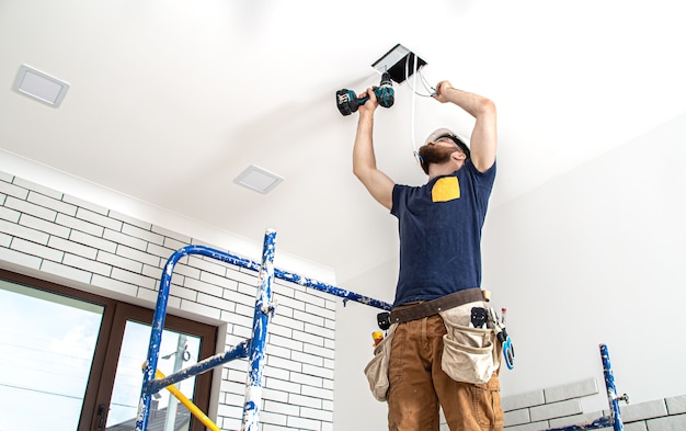 Onderaanzicht professional in overall met gereedschap op de reparatielocatie. Home renovatie concept.