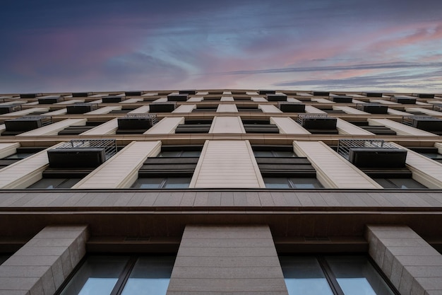 Onderaanzicht van de gevel van een modern flatgebouw met meerdere verdiepingen