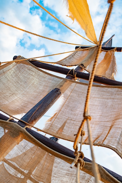 Onderaanzicht van een scheepsmast met beige zeilen