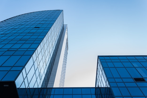 Onderaanzicht van moderne wolkenkrabbers in het zakendistrict tegen de blauwe lucht