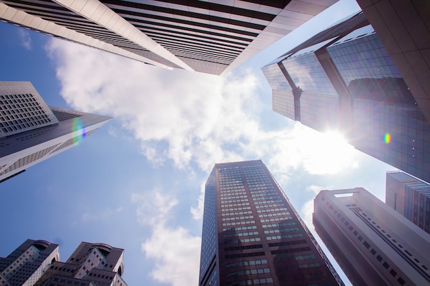 Onderaanzicht van moderne wolkenkrabbers / kantoorgebouwen in het zakelijke district van de steden van Singapore tegen de blauwe hemel. Economie, financiën, bedrijfsactiviteit concept. Kopieer ruimte voor inhoud.