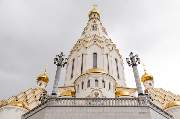 Onderaanzicht van witte christelijke kerk met vergulde koepels