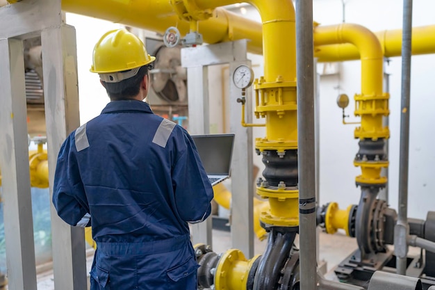 Onderhoudsmonteur bij een verwarmingsinstallatiePetrochemische arbeiders houden toezicht op de werking van gas- en oliepijpleidingen in de fabriek Ingenieurs plaatsen gehoorbeschermers Bij kamer met veel leidingen