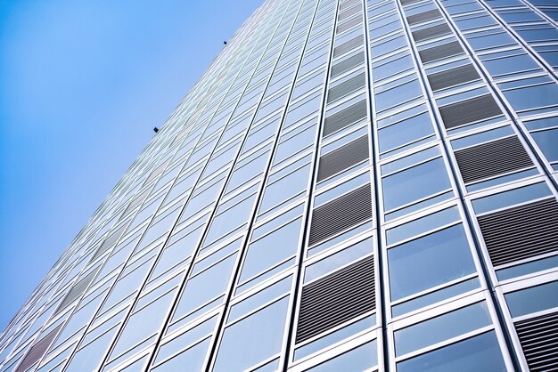 Onderkant panoramisch en perspectief uitzicht op staalblauwe glazen hoogbouw wolkenkrabbers, bedrijfsconcept van succesvolle industriële architectuur