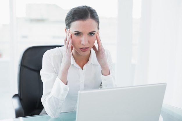 Onderneemster die aan hoofdpijn voor laptop lijdt