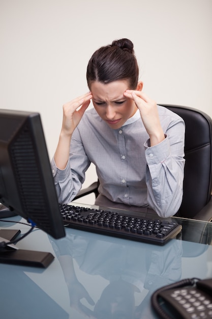 Onderneemster die een hoofdpijn heeft bij haar bureau