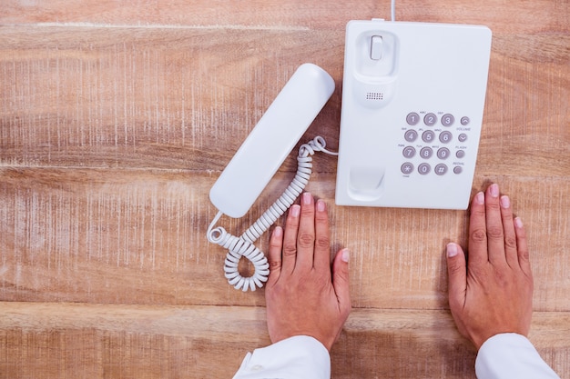 Onderneemster die een telefoon houdt bij haar bureau