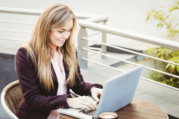 Onderneemster die haar laptop in koffie met behulp van