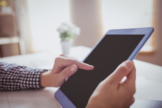 Onderneemster die haar tablet gebruiken bij haar bureau in bureau