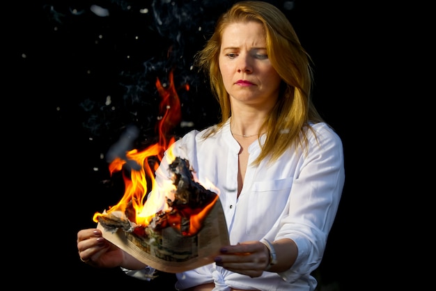 Onderneemster die heet nieuws leest of de aandelenkoersen van het beursnieuws leest. brandend tijdschrift in handen van de vrouw - heet en brekend nieuwsconcept