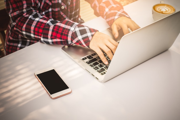 Onderneemster die investeringsgrafieken met laptop computer op bureaulijst analyseren.