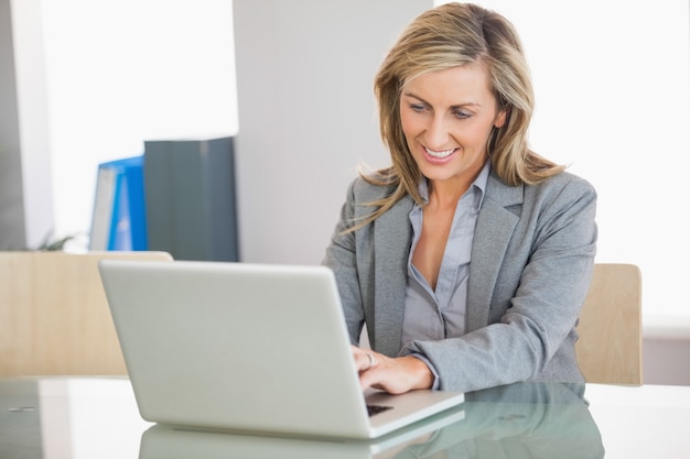 Onderneemster die laptop in een bureau met behulp van