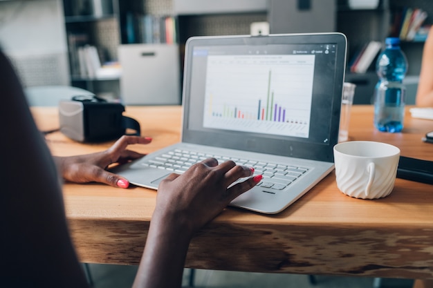 Onderneemster die met laptop in modern bureau schrijven en een project plannen